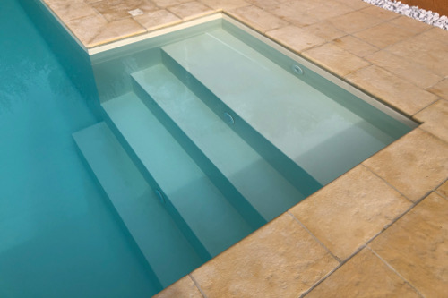 scala piscina Acqua SPA in cemento armato isolato rettangolare con rivestimento antisdrucciolo in PVC colore sabbia e piastrellatura esterna in nature stone giallo